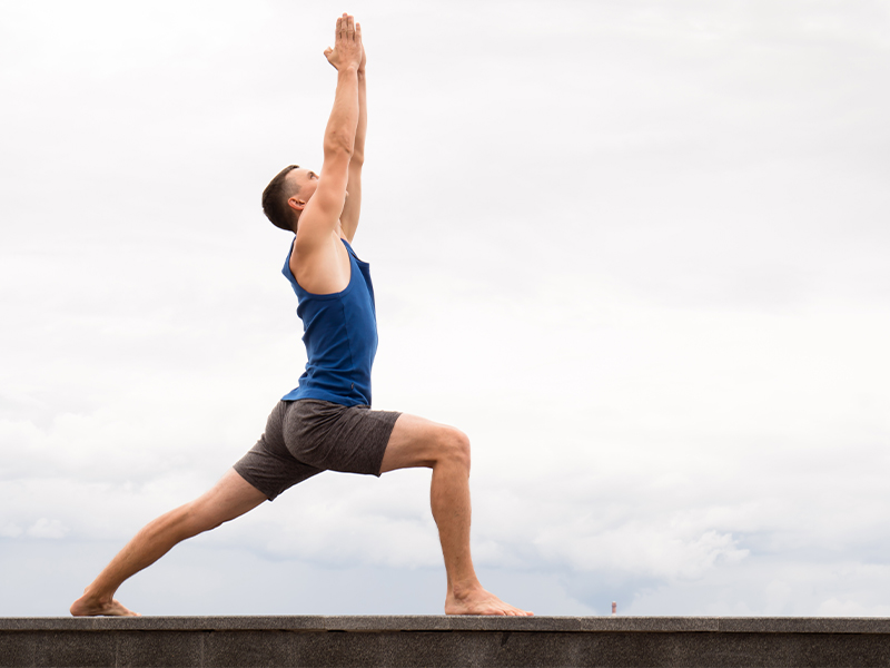Ein Mann beim Yoga macht den Krieger 1.