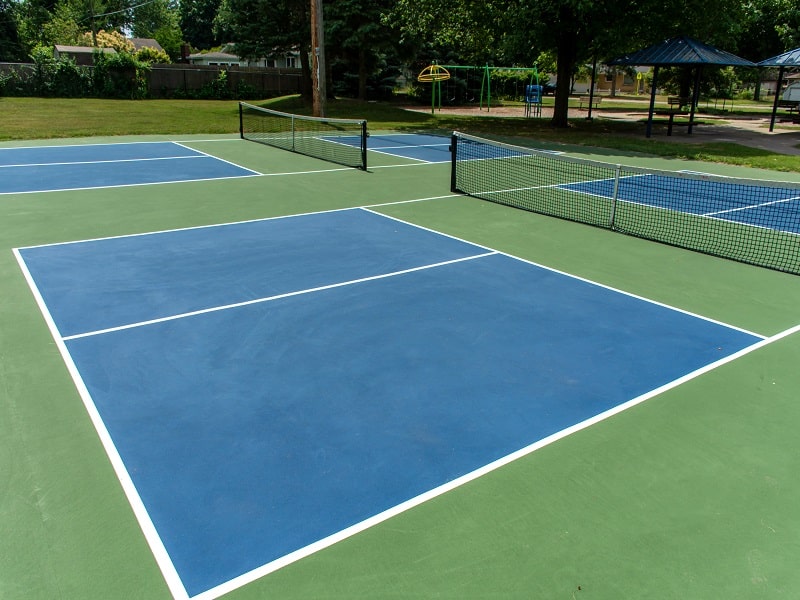 Ein Pickleball-Feld ist 13,4 x 6,1 Meter groß und wird durch ein 0,9 Meter hohes Netz in zwei Hälften geteilt.