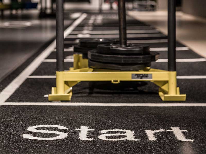 Im Gym heißt der Gewichtsschlitten auch Prowler oder Power Sled. Er ist ein Gestell aus Metall, dass du über eine gewisse Strecke schiebst oder ziehst.