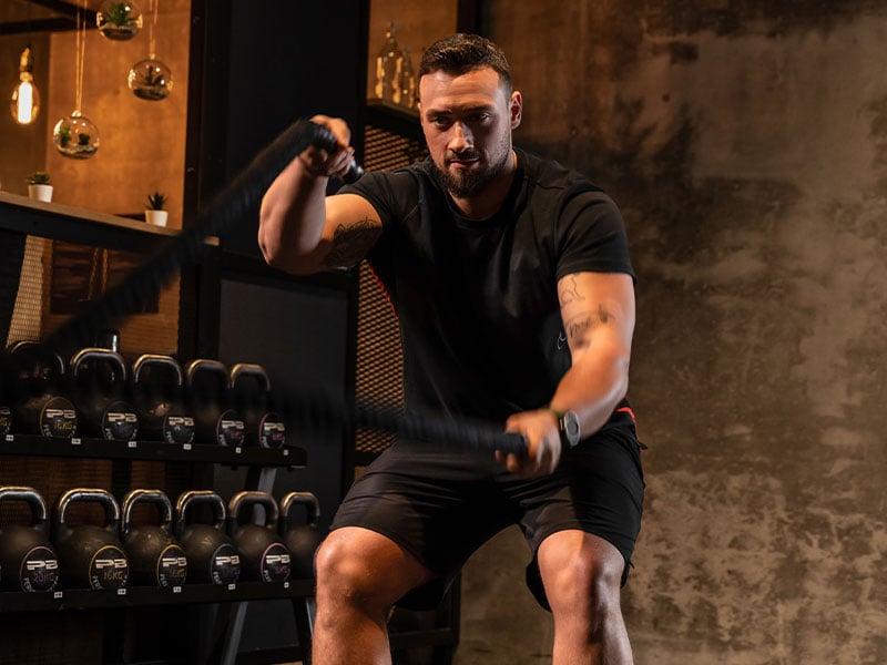 Mit der AMRAP-Workout-Methode verbesserst du deine Kraftausdauer, z. B. mit Battle Ropes.