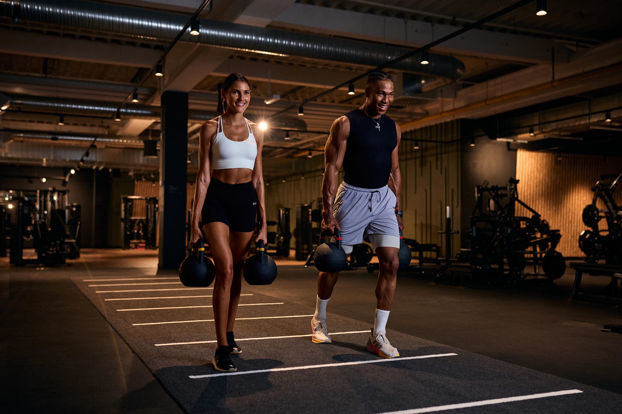 Junges Paar macht Kettlebell Farmers Carry